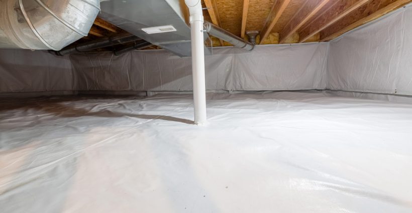 Crawl space fully encapsulated with thermoregulatory blankets and dimple board. Radon mitigation system pipes visible. Basement location for energy saving home improvement concept.