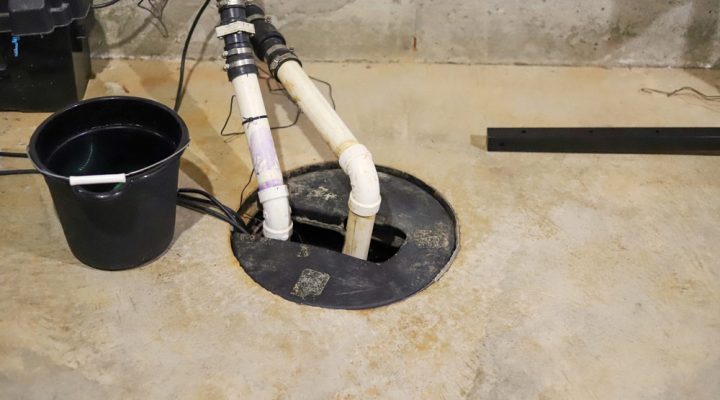 A backup battery for sump pump, a black pail, and discharge pipes